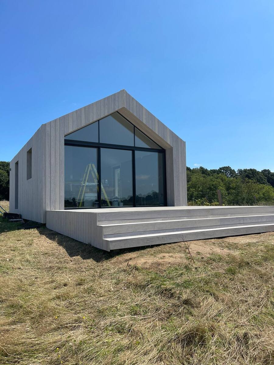 Modern timber-clad garden building with glazed gable
